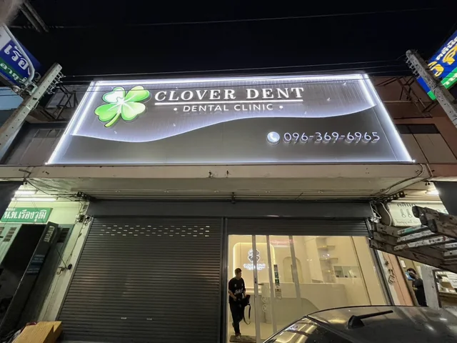 ป้ายไฟ Clover Dent Dental Clinic ยามค่ำคืน ตัวอักษรสีขาวและโลโก้โคลเวอร์สีเขียวเหนือหน้าคลินิก