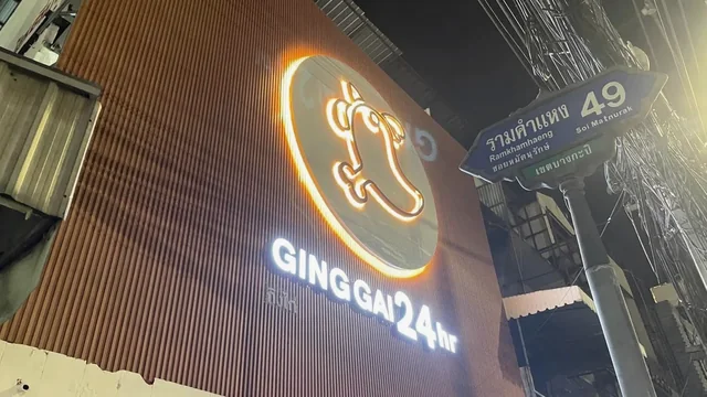 ป้ายไฟ GINGGAO 24 hr หน้าร้านอาหารกลางคืน โลโก้เรืองแสงบนฟาซาดลายไม้