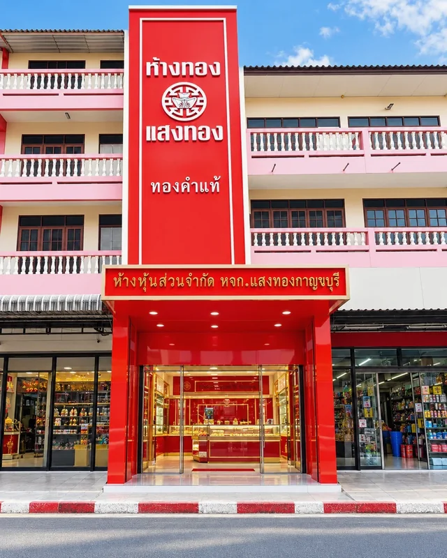ฟาซาดห้างทองแสงทองสีแดง พร้อมป้ายแนวตั้ง ตัวอักษรสีขาวและป้ายเหนือทางเข้าร้าน