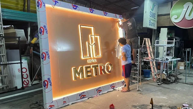 ขั้นตอนประกอบป้ายไฟ Hotel Metro ตัวอักษรสีทอง พร้อมทดสอบแสงบนแผงป้ายภายในโรงงานผลิต