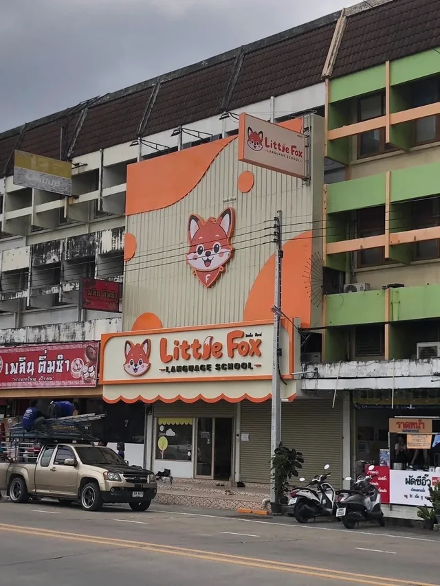 หน้าอาคาร Little Fox Language School พร้อมป้ายโลโก้รูปสุนัขจิ้งจอก สีส้มและครีม และป้ายชื่อโรงเรียนสอนภาษา